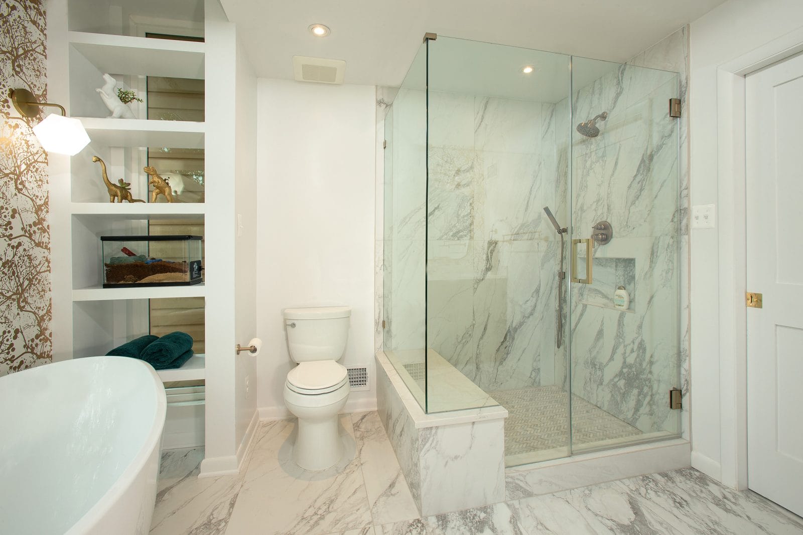 Luxurious bathroom featuring a frameless swinging glass enclosure, marble walls, and a built-in shower bench, creating a sleek and spa-like retreat.