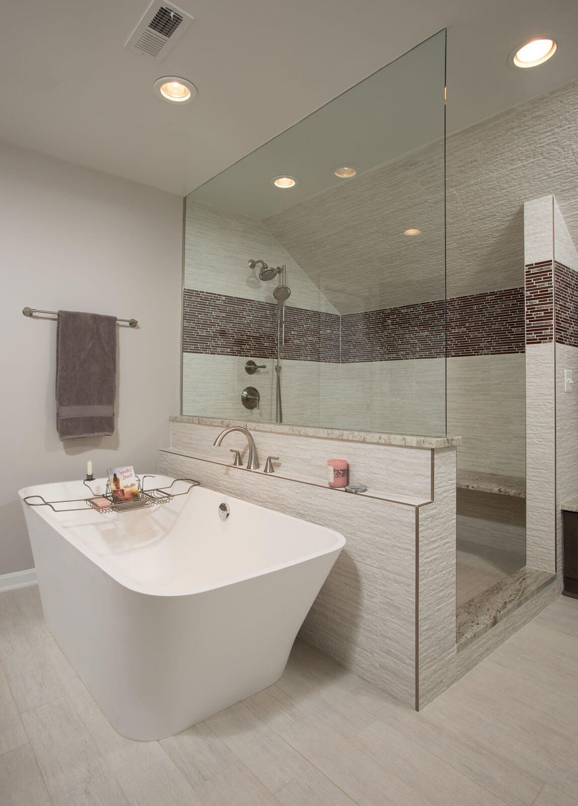Luxury frameless shower enclosure with textured wall tiles and a freestanding tub, creating a modern and elegant bathroom design.