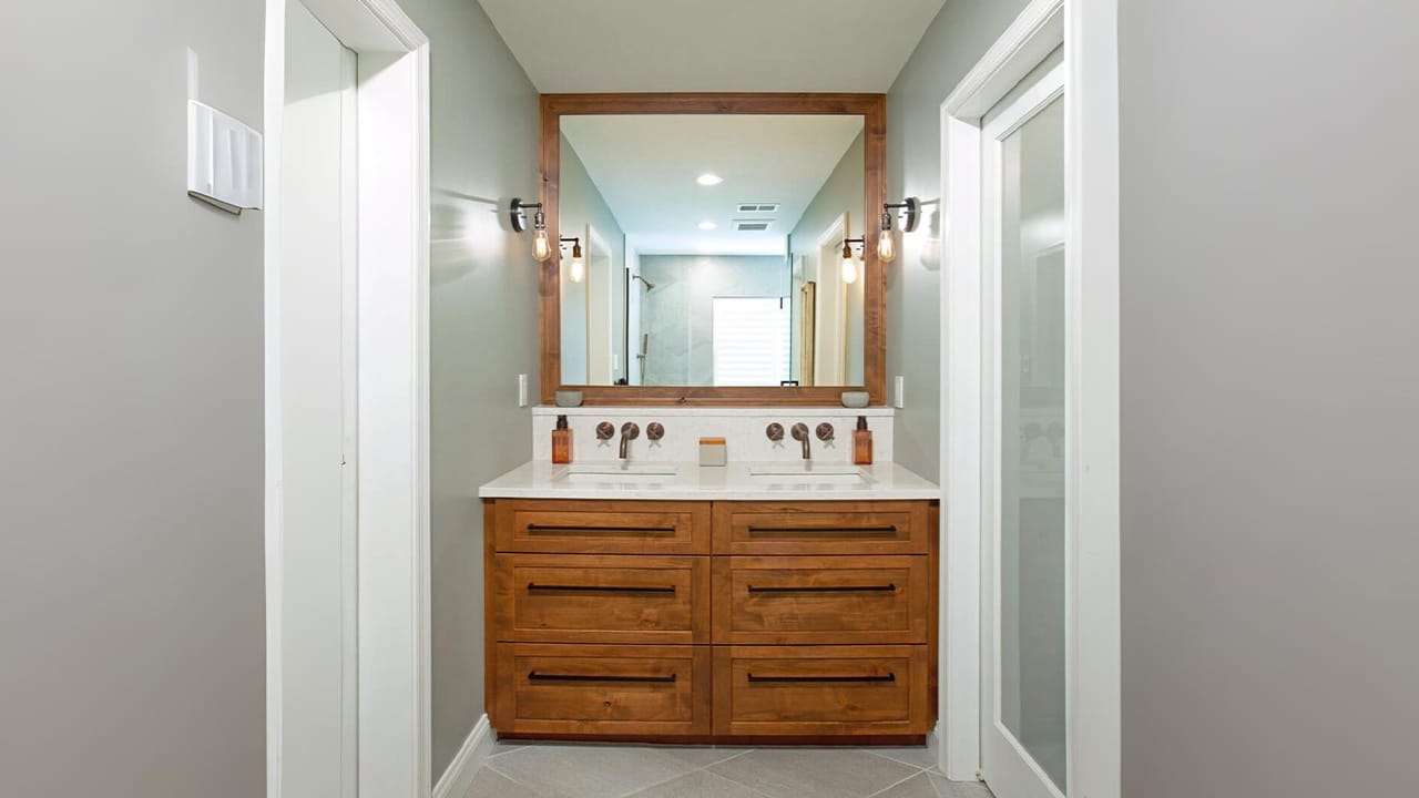 Rustic wood vanity with dual sinks and a framed mirror in a minimalist modern bathroom